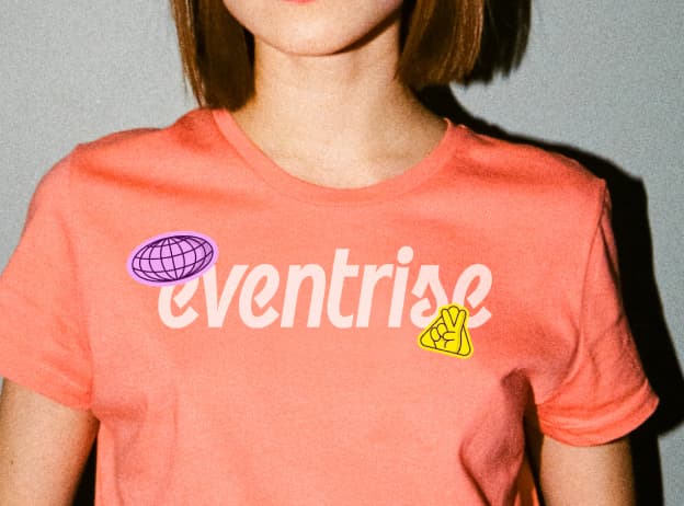 Eventrise branded coral t-shirt with custom wordmark logo, globe illustration, and peace hand icon